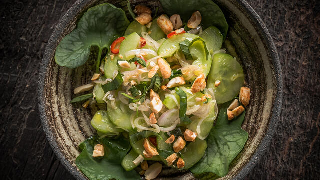 Komkommersalade met Thaise basilicum, sjalot, limoen, rode piment, geroosterde pinda’s en Syrha Leaves